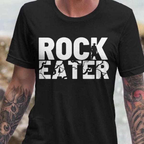Rock eater t shirt on a man at the beach.